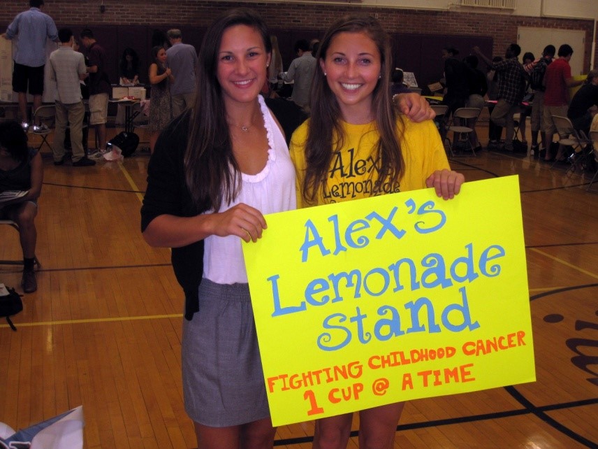 Two Lemon Club Students Holding Alex's Lemonade Sign
